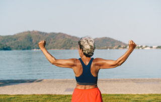Senior gray-haired woman doing exercises in public park