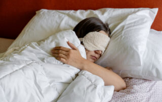 a woman sleeping with a Eye Sleeping Mask on her head