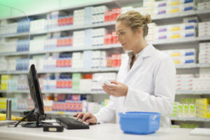 Pharmacist using a computer to look at a prescription in a pharmacy