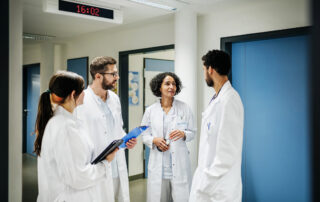 Group Of male and female doctors in white coats Chatting On The Ward