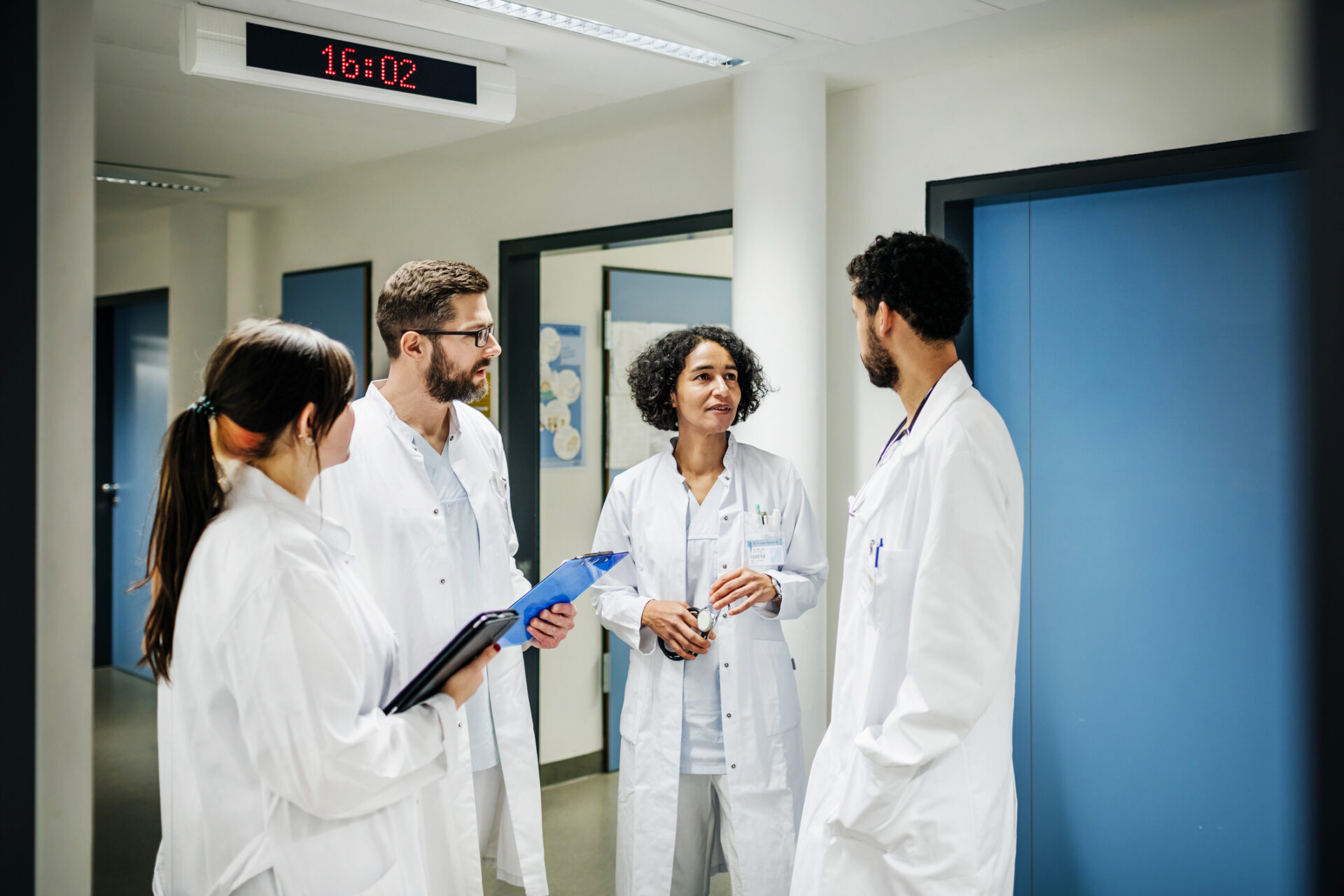 Group Of male and female doctors in white coats Chatting On The Ward