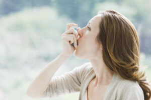 Woman with inhaler for asthma