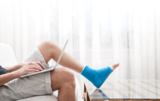 lower half of man sat on sofa with ankle cast