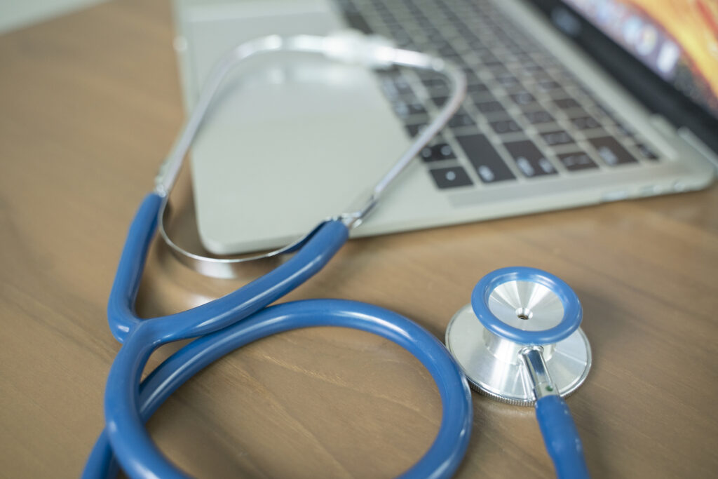 Doctors desk with stethoscope and laptop