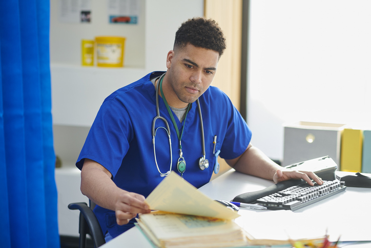 Doctor sitting at a desk with paperwork